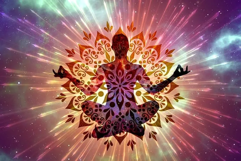 Image d'une personne assise en méditaion avec une aura de chakra